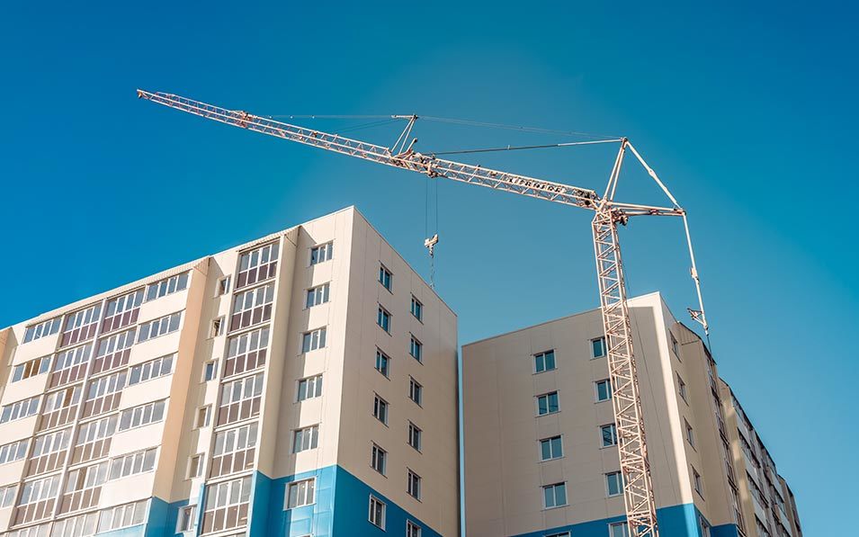 a crane next to a tall building